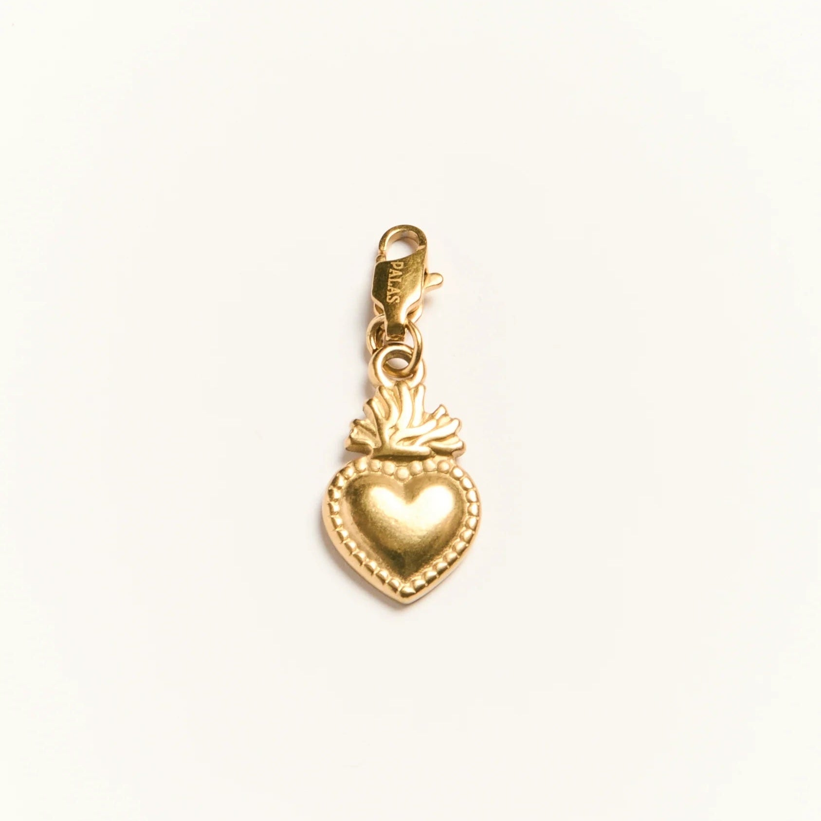 Gold heart-shaped charm on a white background