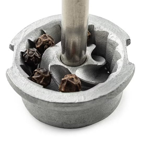 Metallic grinder with pepper on a white background