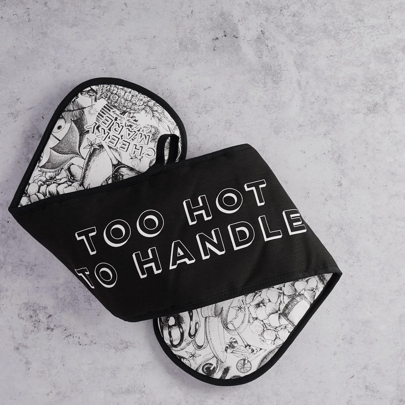 Black oven mitt with 'Too Hot to Handle' text on a gray background