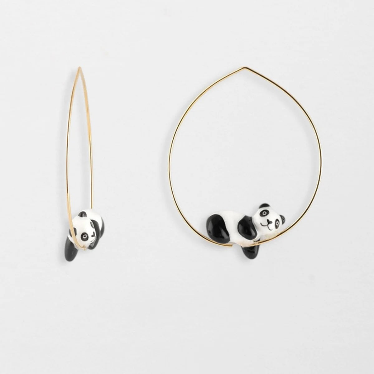 Panda-shaped earrings on a light gray background