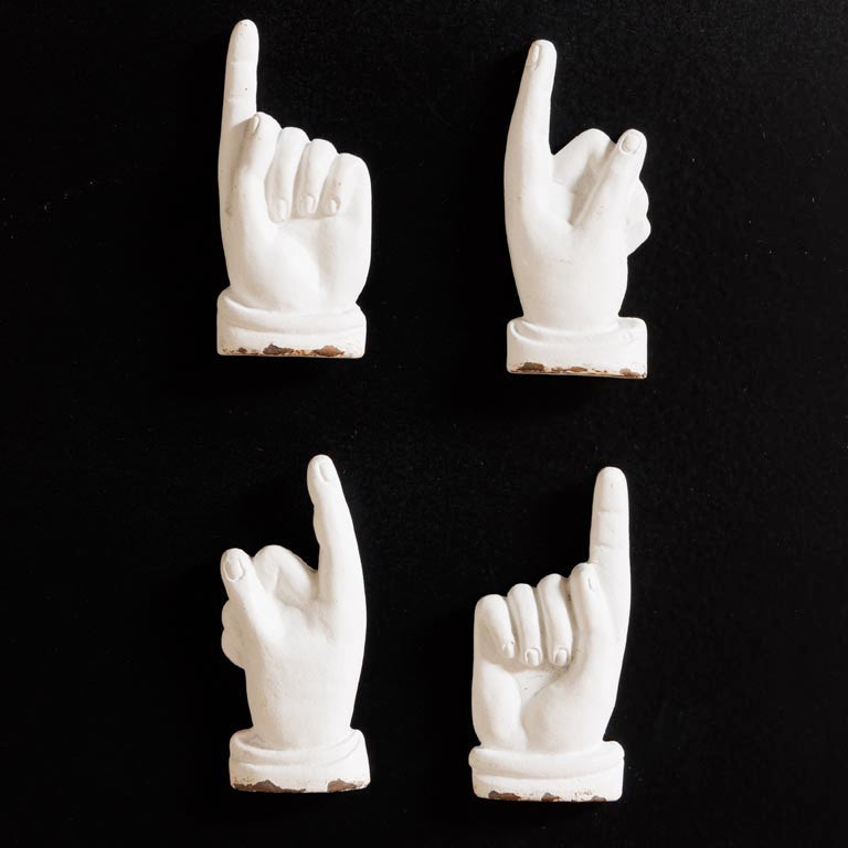 Four white hand gestures on a black background