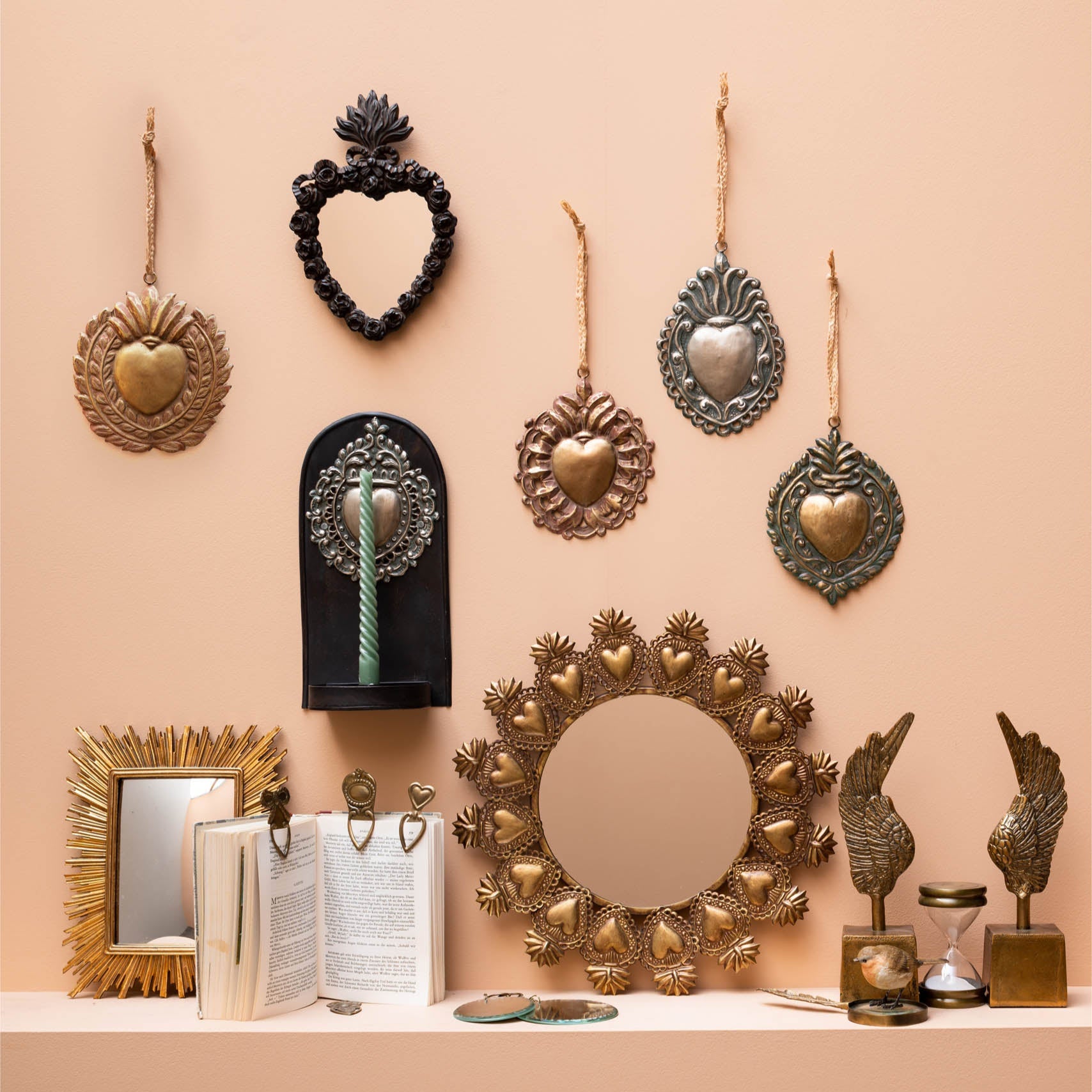Decorative wall art and home decor items on a peach-colored wall.