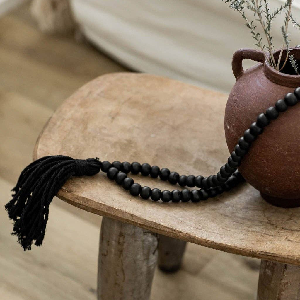 Strand of small round black wooden decor beads with tassel – Jitana