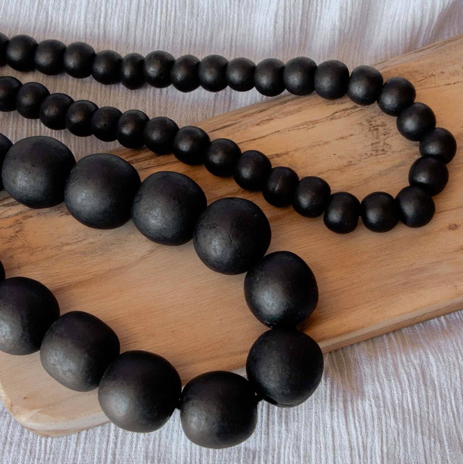 Close-up of handcrafted 1.5 cm black beads on a decorative garland – Jitana