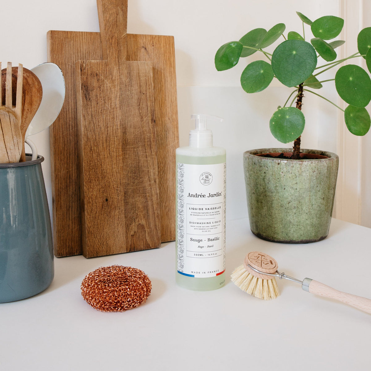 Copper scouring ball on a kitchen counter with wooden boards, dish soap and a plant – Andrée Jardin