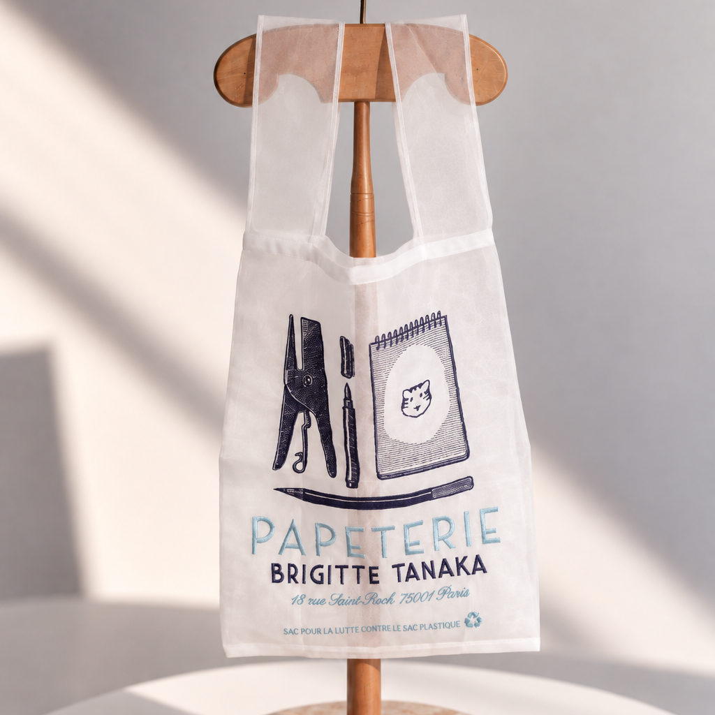 Organza bag embroidered in navy with pencils, a pen and a tiger notebook, on a wooden hanger – Brigitte Tanaka