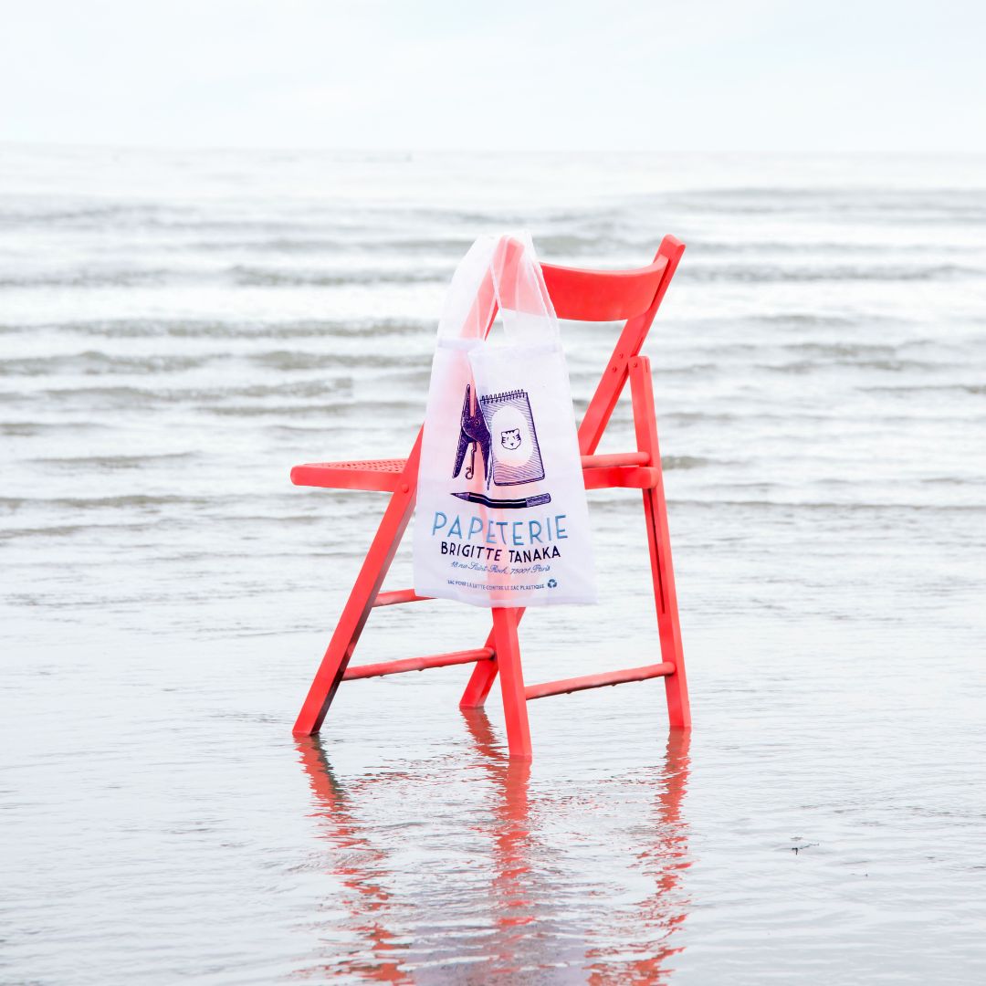 Papeterie organza bag hanging from a red chair standing in the sea – Brigitte Tanaka