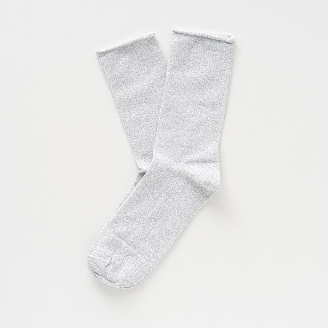 White socks with a fine silver glitter, laid flat to show the rolled cuffs – KLUE