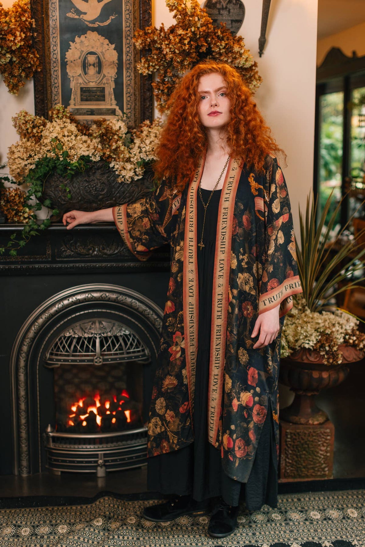 Black rose-print duster kimono worn open beside a lit fireplace – Market of Stars