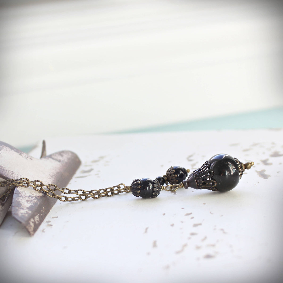 Black agate and onyx pendulum with brass cap and bead detail – Circa 1890