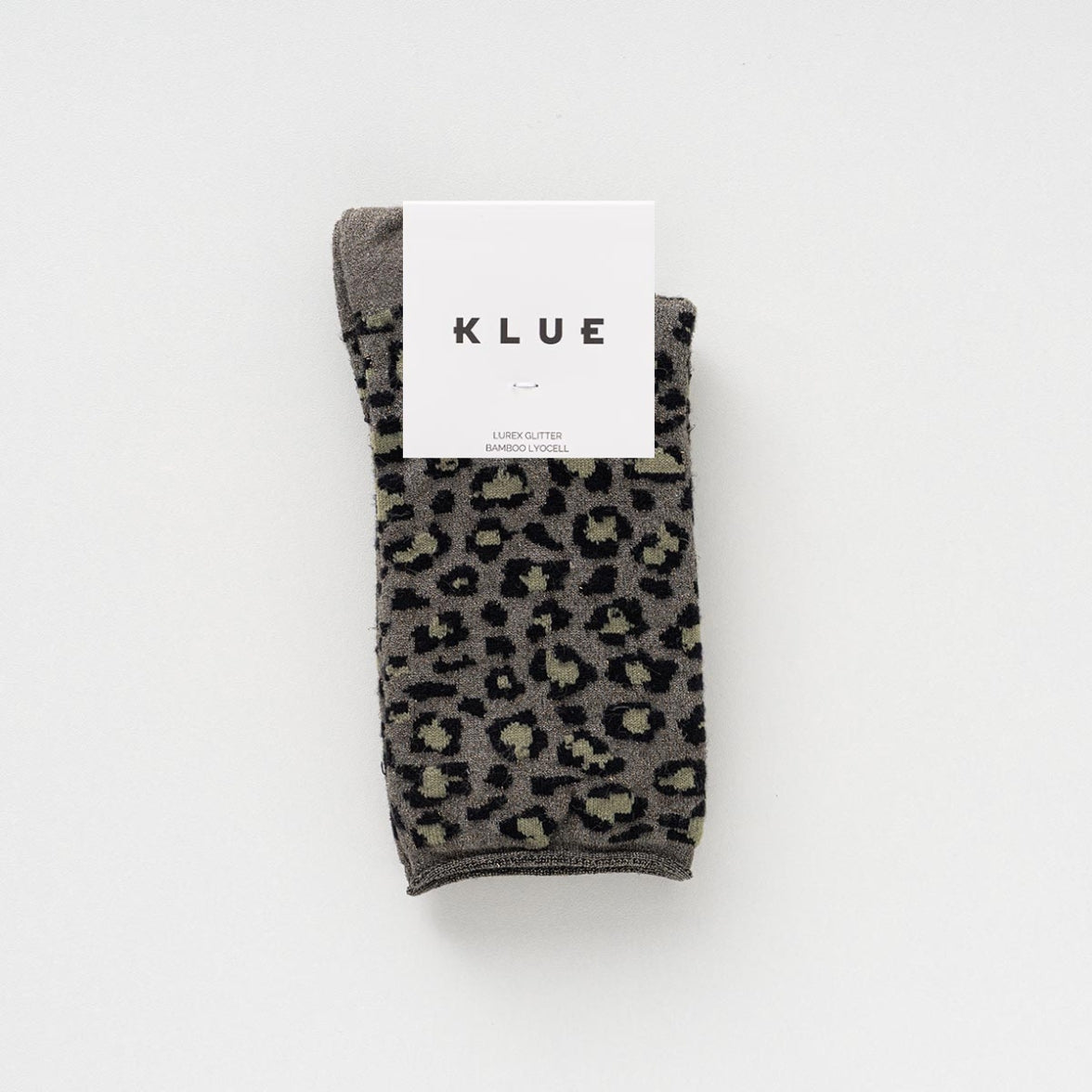 Folded pair of khaki and grey leopard-print socks with glitter in a KLUE paper band – KLUE