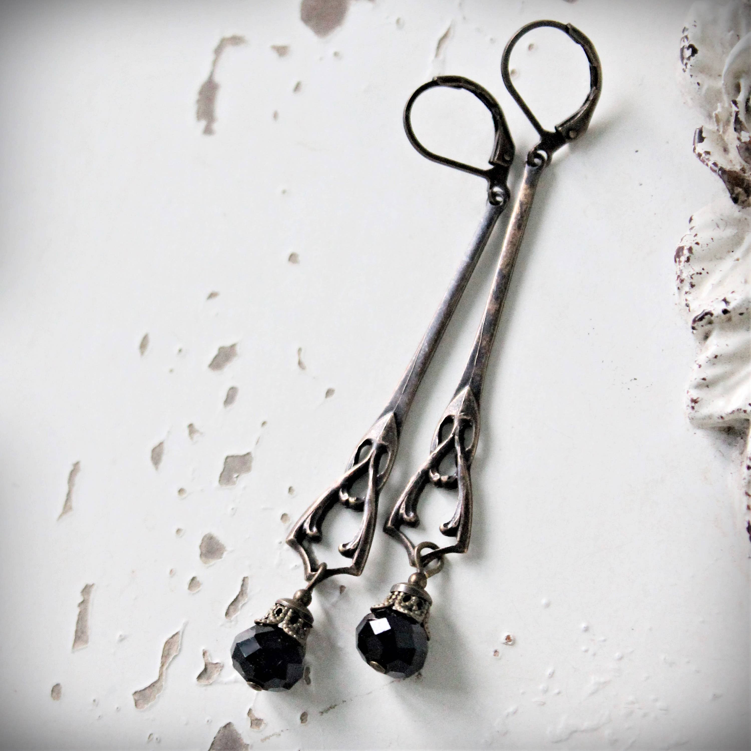 Long jet-black Art Nouveau drop earrings in flowing antique-gold brass – Circa 1890