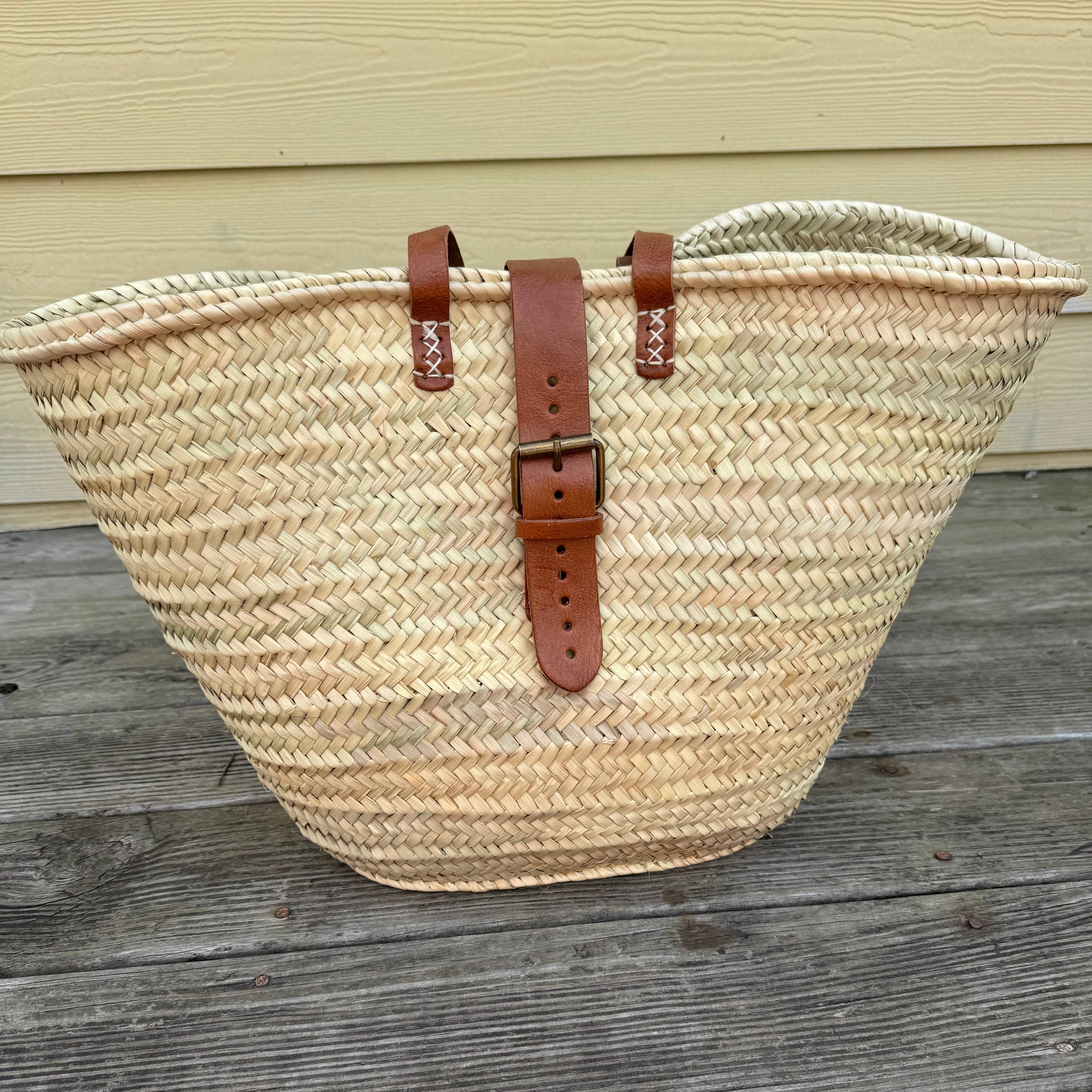 Natural woven palm market basket with tan leather handles and a front buckle strap – Medina
