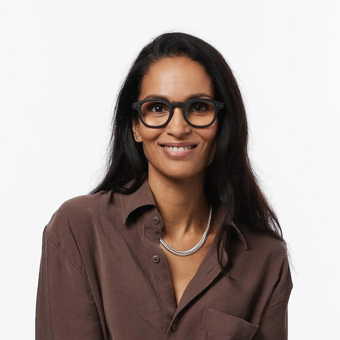 Woman wearing glasses and a brown shirt on a white background