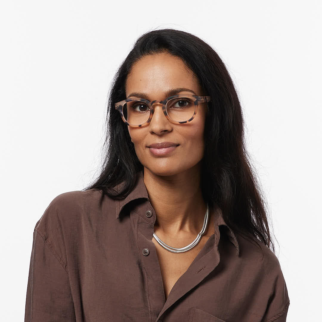 Woman wearing a brown shirt and glasses on a white background
