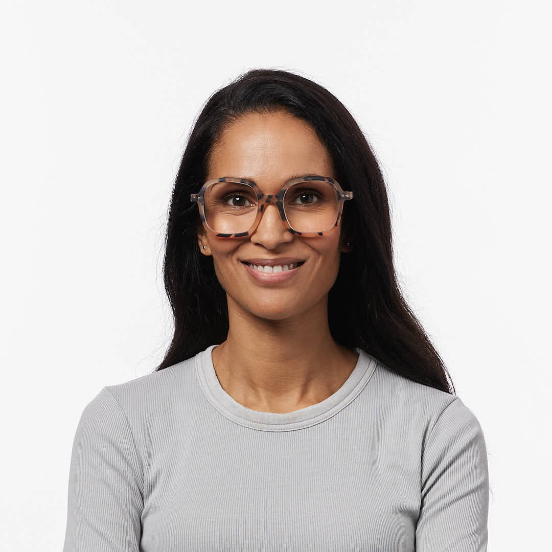 Woman wearing glasses and a gray sweater on a white background