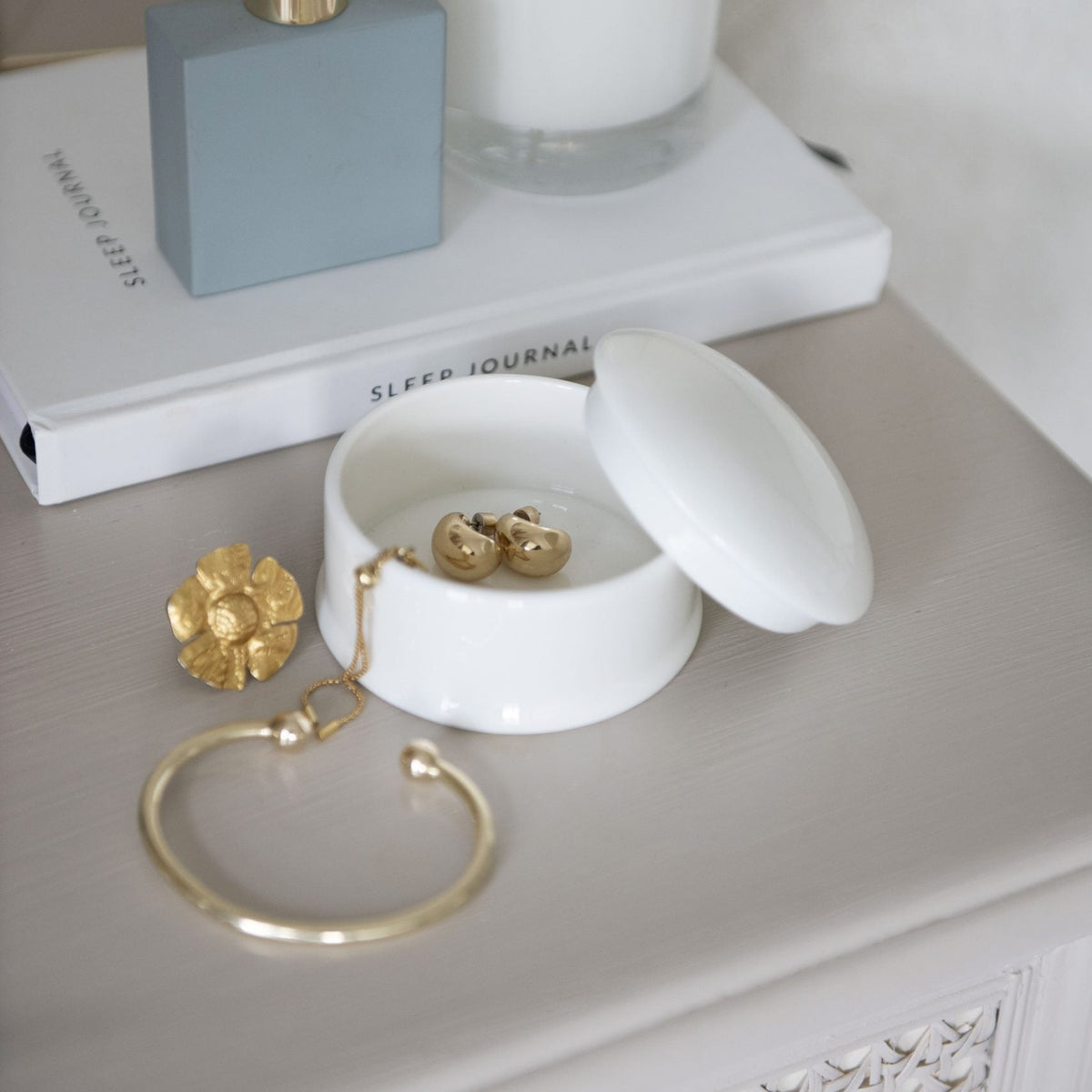 White porcelain round trinket box with lid set aside, holding gold earrings – Buttercup