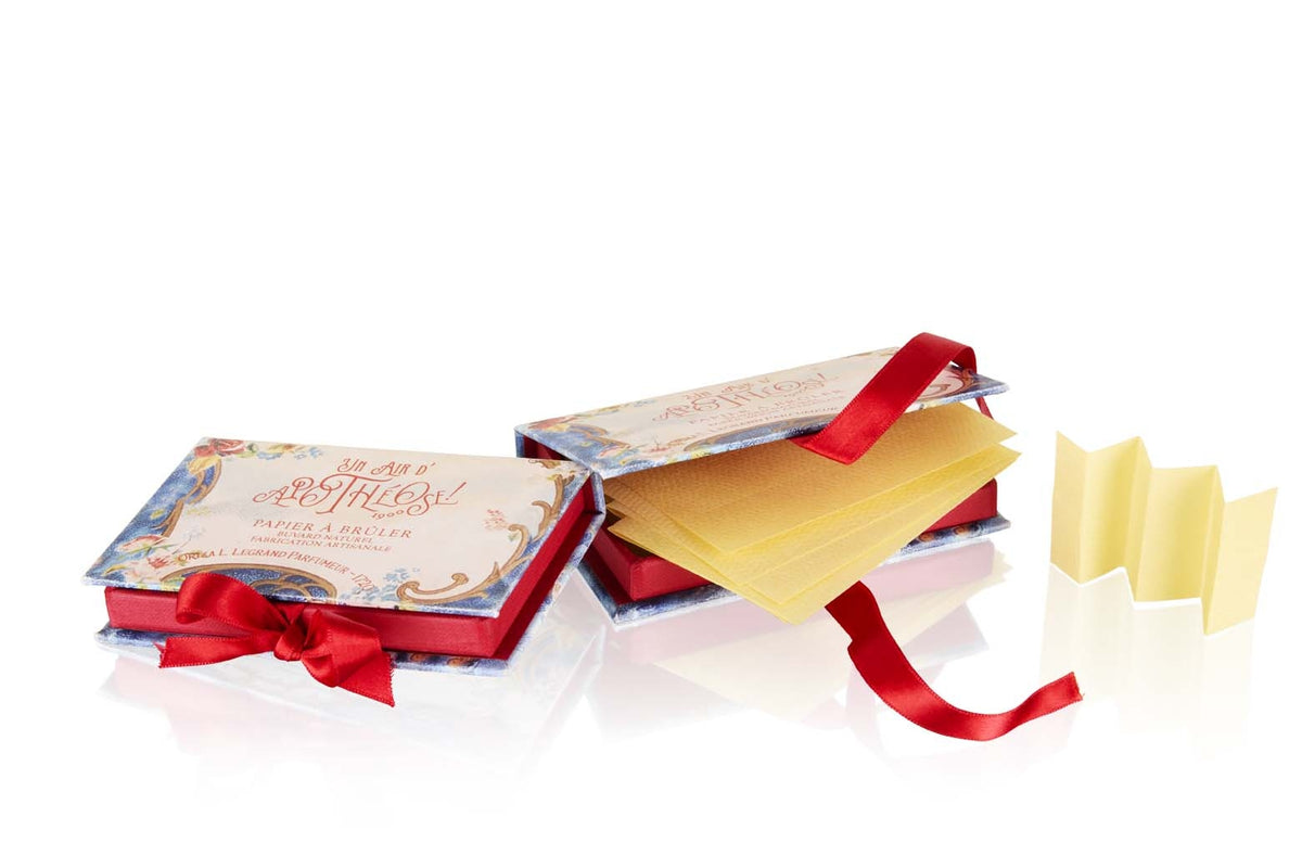 Open blue illustrated box of pale yellow scented paper strips tied with red ribbon – Oriza L. Legrand