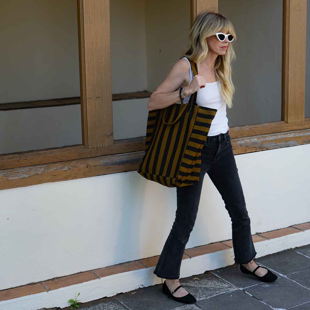 Woman walking with the cumin striped tote slouched over her shoulder – Rose in April