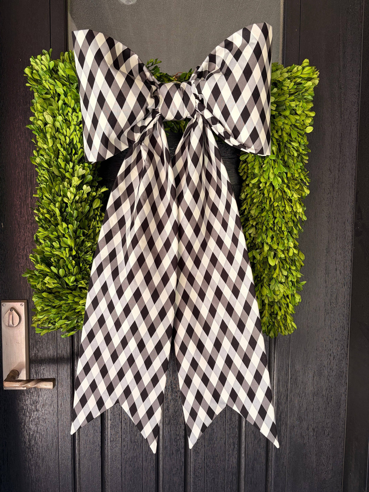 Black and white harlequin check bow with long tails over a boxwood wreath – La Maison Reverie