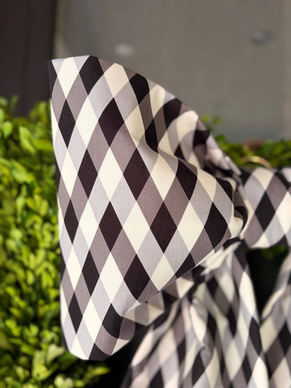 Close-up of a full bow loop in black and white diamond-check cotton – La Maison Reverie