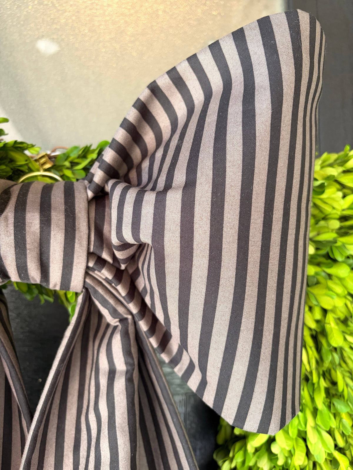 Close-up of a sculpted loop in charcoal and ivory ticking-stripe cotton – La Maison Reverie