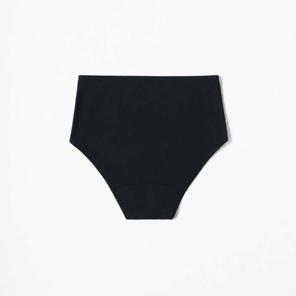 Black high-waist bikini styled on the beach, minimal seamless finish – Blanche Edit