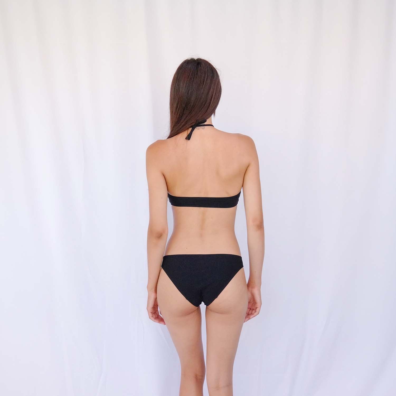 Seaside view of the black bandeau top worn with the removable halter tie – Blanche Edit